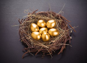 36140864 - gold eggs in nest from hay on table