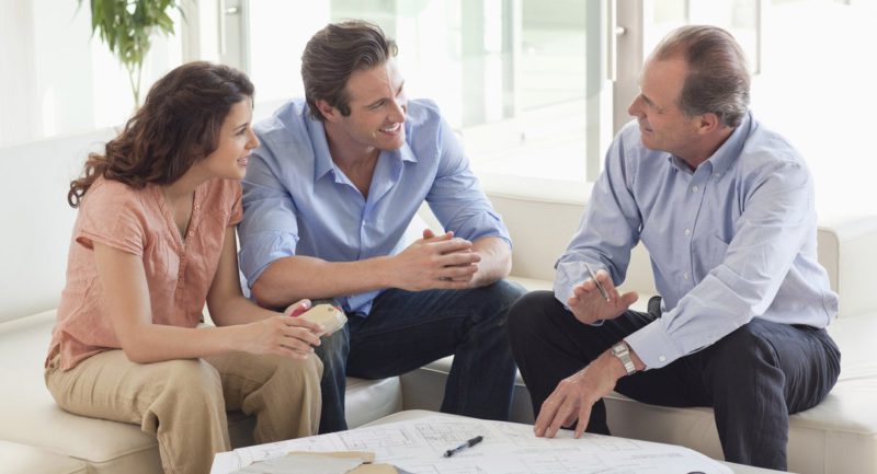 Couple sitting on sofa talking to financial advisor